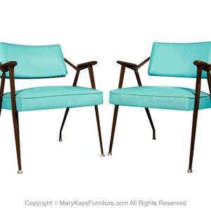 May include: Two turquoise blue chairs with dark brown wooden legs and arms. The chairs are positioned facing each other.