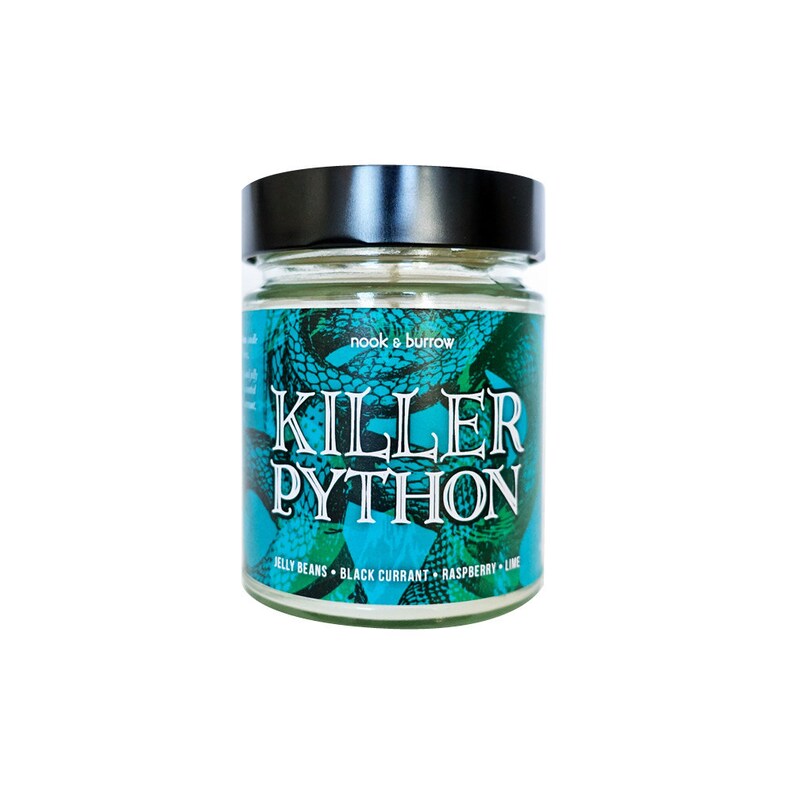 May include: A glass jar candle with a black lid. The label is green and blue with a snake design and the text "nook & burrow" and "KILLER PYTHON" in black. The text "JELLY BEANS - BLACK CURRANT - RASPBERRY - LIME" is also on the label.