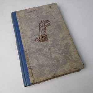 May include: A vintage hardcover book with a blue spine and a brown illustration of a stylized animal head on the front cover.