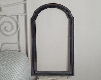 Könnte beinhalten: Ein schwarzer, gewölbter Bilderrahmen mit einer abgenutzten Oberfläche. Der Rahmen ist aus Holz und hat ein schlichtes Design.