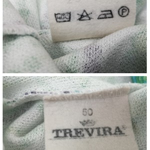 May include: White fabric label with black text and symbols. The text reads "257359" and "Trevira 100% Polyester". The symbols are for washing instructions. The label also has a number "50" printed on it.
