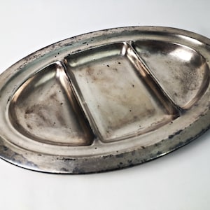 May include: A silver oval serving tray with three divided sections. The tray has a slightly worn finish.