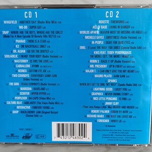 May include: A blue CD case with a white border and a list of songs on each side. The front of the case has the title "CD 1" and "CD 2" printed in white. The back of the case has a barcode and the text "7 43212 48302 4".