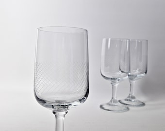 May include: Three clear glass wine glasses with a diamond pattern etched into the glass. The glasses have a short stem and a wide bowl.