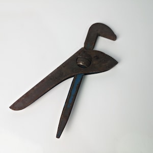 May include: A rusty adjustable wrench with a blue handle. The wrench is in a crossed position.