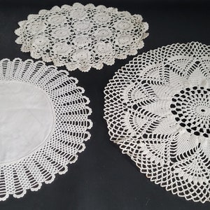 May include: Three white crocheted doilies of varying sizes and patterns.