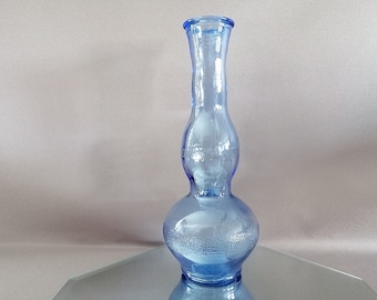 May include: A light blue glass vase with a bulbous shape and a textured surface.