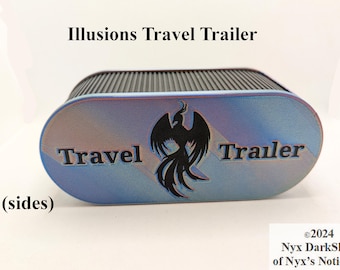 May include: A blue and purple travel trailer with the text "Illusions Travel Trailer" and a black phoenix design. The text "Travel" and "Trailer" are on the sides of the trailer.