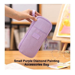 May include: A small purple zippered pouch with a handle. The pouch has a white label that says "SO MUCH SPACE".