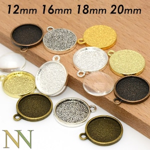 Puede incluir: Surtido de engastes redondos de metal de 12 mm, 16 mm, 18 mm y 20 mm con una variedad de acabados, incluyendo oro, plata y bronce antiguo. Los engastes tienen una superficie texturizada y un bucle para colgar.