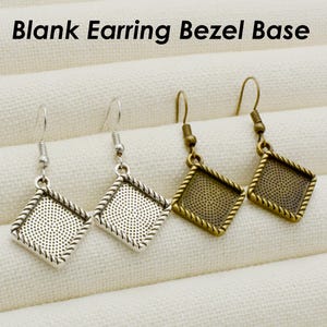 Puede incluir: Cuatro bases de bisel para pendientes, dos plateadas y dos doradas, con forma de diamante y borde texturizado. Las bases de pendientes se muestran sobre un fondo de tela blanca. El texto "Blank Earring Bezel Base" se muestra en la parte superior de la imagen.