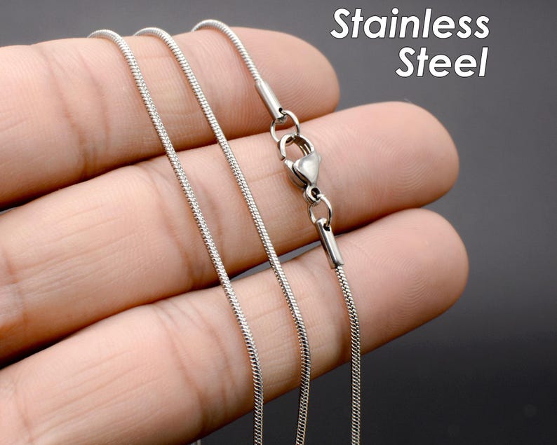 May include: A silver chain necklace with a lobster clasp closure. The chain is made of stainless steel.