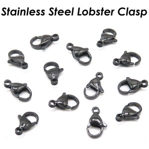 May include: A close-up of 12 black stainless steel lobster clasps. The clasps are small and have a shiny finish.