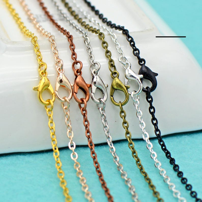 May include: Seven different colored chains with lobster claw clasps. The chains are gold, silver, rose gold, copper, black, and two shades of bronze.