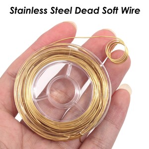 May include: A spool of gold-colored stainless steel dead soft wire. The wire is wound around a clear plastic spool with a center hole.