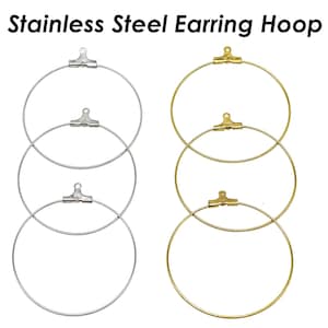 Pode incluir: Dois conjuntos de argolas para brincos de aço inoxidável. Um conjunto é prateado e o outro é dourado. Cada conjunto tem três argolas de tamanhos diferentes.