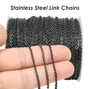 May include: A spool of black stainless steel link chain. The chain is shown in a close-up with a hand holding three strands of the chain.
