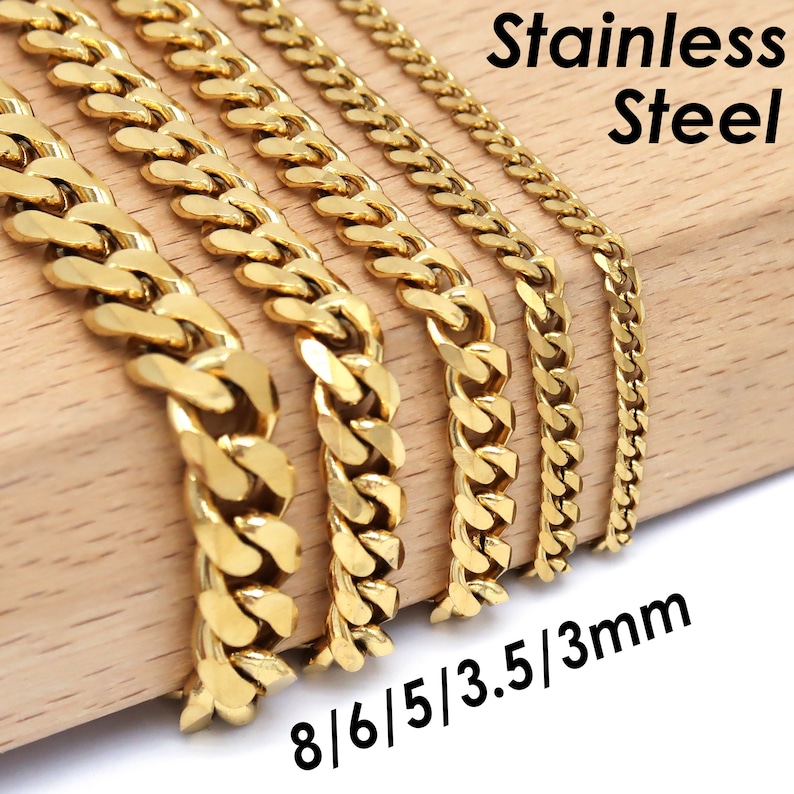 Op de afbeelding: Goudkleurige roestvrijstalen gourmetkettingen in verschillende breedtes: 8 mm, 6 mm, 5 mm, 3,5 mm en 3 mm. De kettingen worden gepresenteerd op een houten oppervlak met de tekst "Stainless Steel".