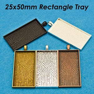 May include: Five different 25x50mm rectangle trays. The trays are made of metal and have a textured surface. The trays are in different colours, including black, silver, gold, and copper.