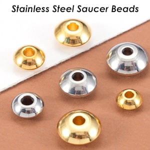May include: A collection of stainless steel saucer beads in gold and silver finishes. The beads are round and have a flat, saucer-like shape. They are perfect for jewelry making or other craft projects.