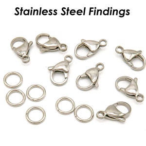 May include: A collection of silver-toned metal clasps and jump rings. The clasps are lobster claw style and the jump rings are round.  Stainless Steel Findings.