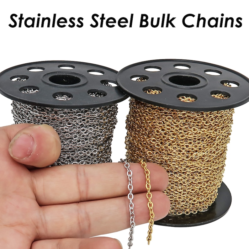 May include: Two spools of stainless steel chain, one gold and one silver, on black spools. The chain is on a white background.