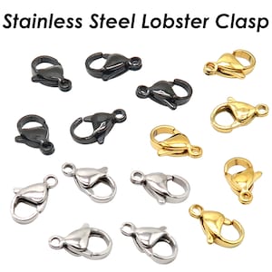Könnte beinhalten: Edelstahl-Hummerverschlüsse in Schwarz, Gold und Silber. Die Verschlüsse sind vor einem weißen Hintergrund abgebildet. Der Text oben lautet "Stainless Steel Lobster Clasp". Diese Verschlüsse werden für die Schmuckherstellung verwendet.
