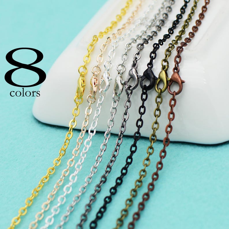 May include: Eight different colored chain necklaces with lobster claw clasps. The chains are gold, silver, rose gold, black, copper, and two shades of bronze.