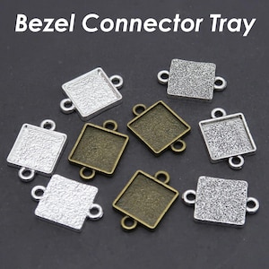 May include: Assortment of silver and bronze bezel connector trays. The trays are square shaped with a textured surface and have two loops on each side.