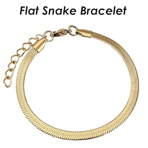 May include: A gold flat snake chain bracelet. The bracelet is made of a thin, flat chain that is linked together in a snake-like pattern.