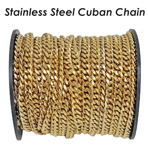 Op de afbeelding: Een spoel met goudkleurige roestvrijstalen Cubaanse ketting. De ketting is strak opgerold en toont de in elkaar grijpende schakels. De tekst "Stainless Steel Cuban Chain" staat bovenaan de afbeelding.