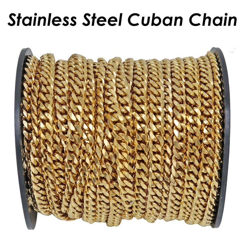 Op de afbeelding: Een spoel met goudkleurige roestvrijstalen Cubaanse ketting. De ketting is strak opgerold en toont de in elkaar grijpende schakels. De tekst "Stainless Steel Cuban Chain" staat bovenaan de afbeelding.
