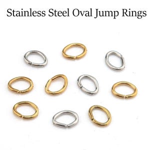 May include: A collection of stainless steel oval jump rings in gold and silver tones. The rings are open, ready for use in jewelry making or other crafts. Text at the top reads "Stainless Steel Oval Jump Rings."