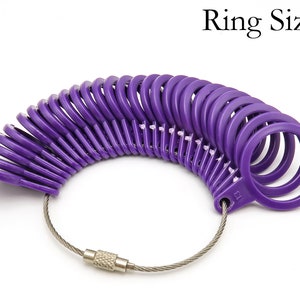 May include: Purple plastic ring sizer with a metal chain. The sizer has a range of sizes from 1 to 13.