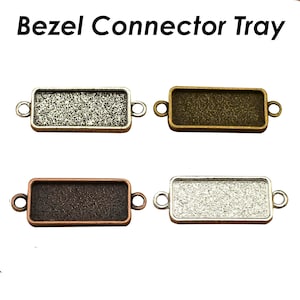 May include: Four bezel connector trays in different finishes: silver, bronze, copper, and antique silver. Each tray has two loops on either side for attaching to jewelry.