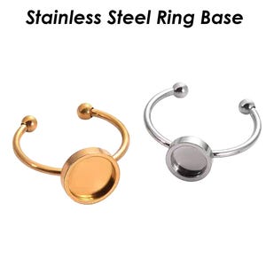 May include: Two stainless steel ring bases, one gold and one silver, with a round, flat, blank center for adding a design or image.
