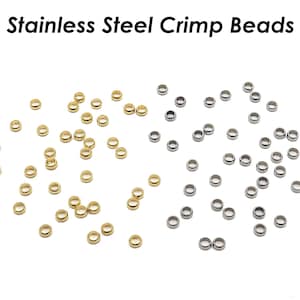 Peut inclure: Image rapprochée de deux tas de perles à sertir. Un tas est doré et l'autre est argenté.