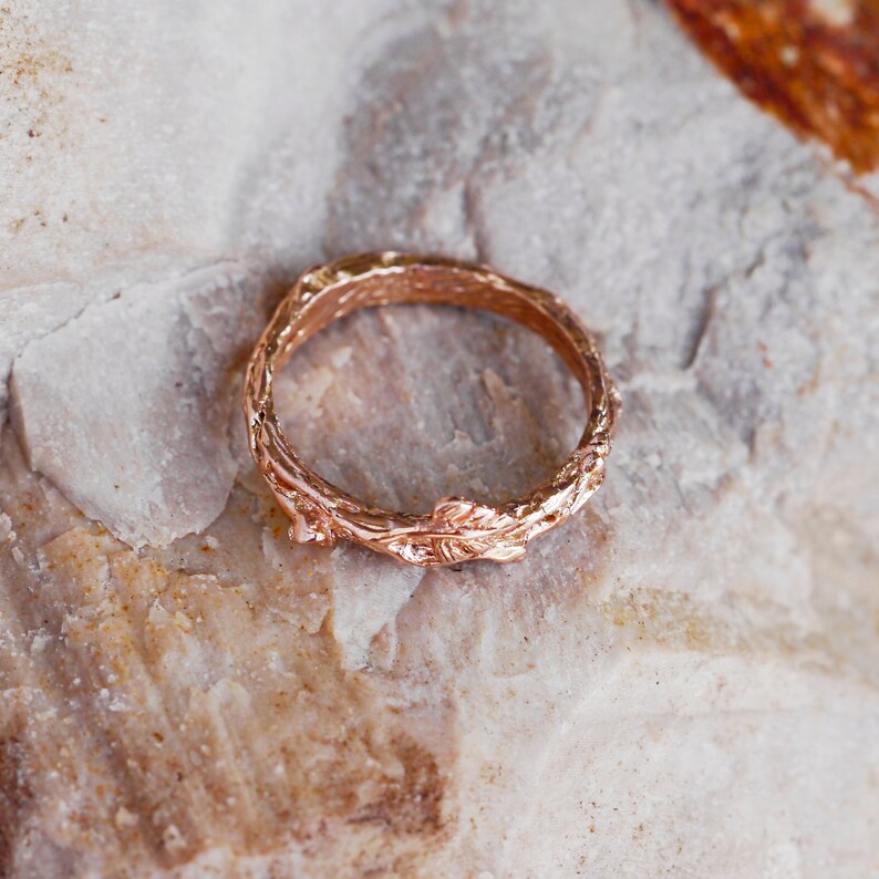 Pu&ograve; includere: Un anello in oro rosa con un design a ramo. L'anello &egrave; fatto per assomigliare a un ramo con foglie.