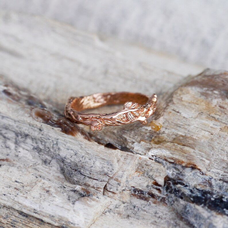 Pu&ograve; includere: Un anello in oro rosa con un delicato design a ramo. L'anello &egrave; realizzato per assomigliare a un ramo con foglie.