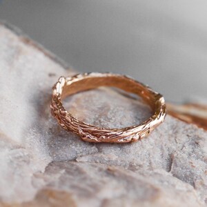 Pu&ograve; includere: Un anello in oro rosa con un design testurizzato a forma di ramo.