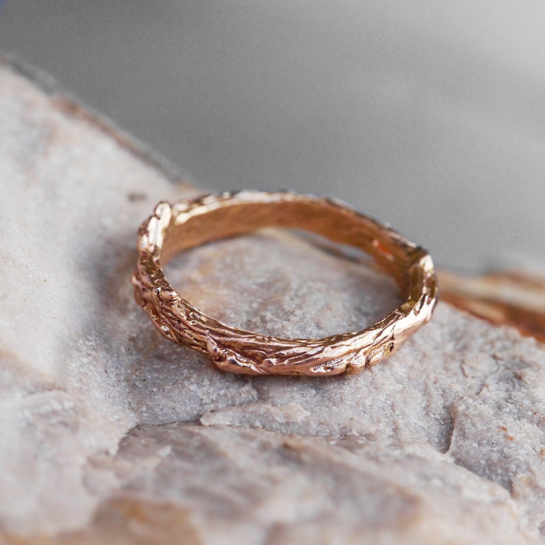 Pu&ograve; includere: Un anello in oro rosa con un design testurizzato a forma di ramo.
