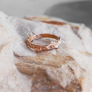 Pu&ograve; includere: Un anello in oro rosa con un delicato design a ramo. L'anello &egrave; realizzato per assomigliare a un ramo con foglie.