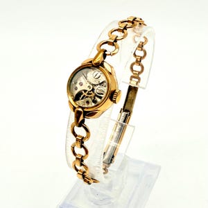 Pulsera de reloj de oro laminado reciclado: alas steampunk y detalles en rubí