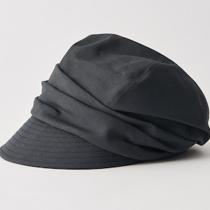 May include: A black newsboy hat with a structured brim and a gathered fabric crown. The hat has a classic design and is made of a solid, dark fabric. The brim is slightly curved and has visible stitching.