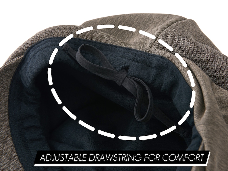 K&ouml;nnte beinhalten: Eine braune Tweed-Kappe mit einem schwarzen, verstellbaren Kordelzug im Inneren. Der Kordelzug ist mit "ADJUSTABLE DRAWSTRING FOR COMFORT" beschriftet.