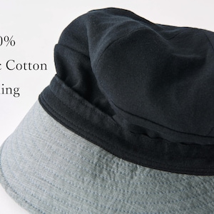 May include: A black hat with a grey brim. The hat has a dark lining and the text "100% Organic Cotton Lining". The hat is made of a soft material and is likely for sun protection.