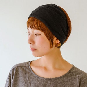 May include: A woman with short, reddish-brown hair is wearing a black headband. She is looking to the side and has a serious expression on her face.