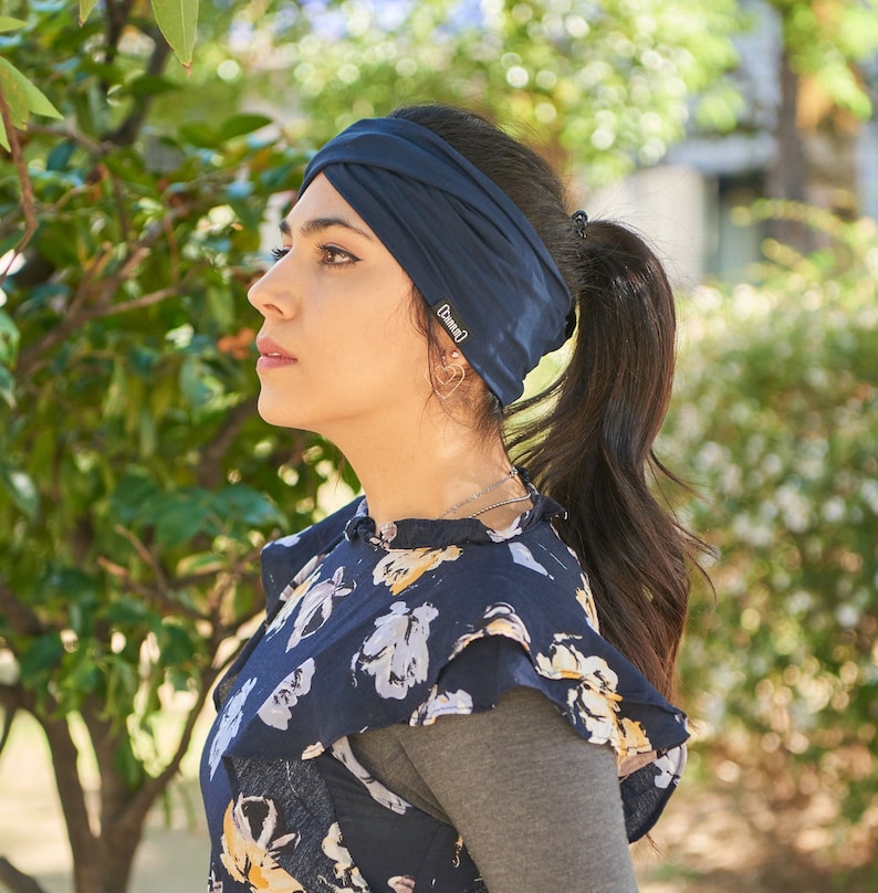 Mexican female model wearing a ponytail and Autumn navy viscose criss cross headband for women with a blue floral dress in Fall