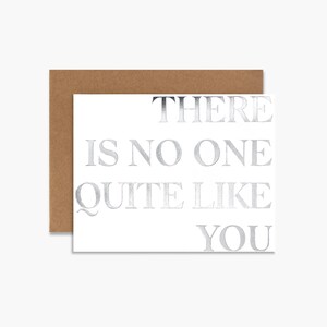 May include: A white card with silver foil lettering that reads "There is no one quite like you". The card has a brown envelope.