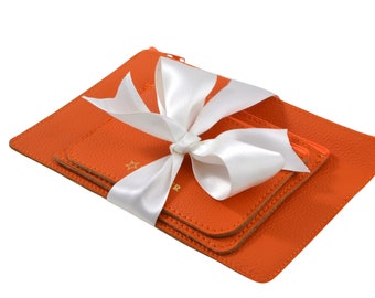 Hand gemaakte luxe set van 3 tasjes in oranje leer. Gebruik ze als portomonnee, toilettasje, voor make up, medicijnen of pennen.